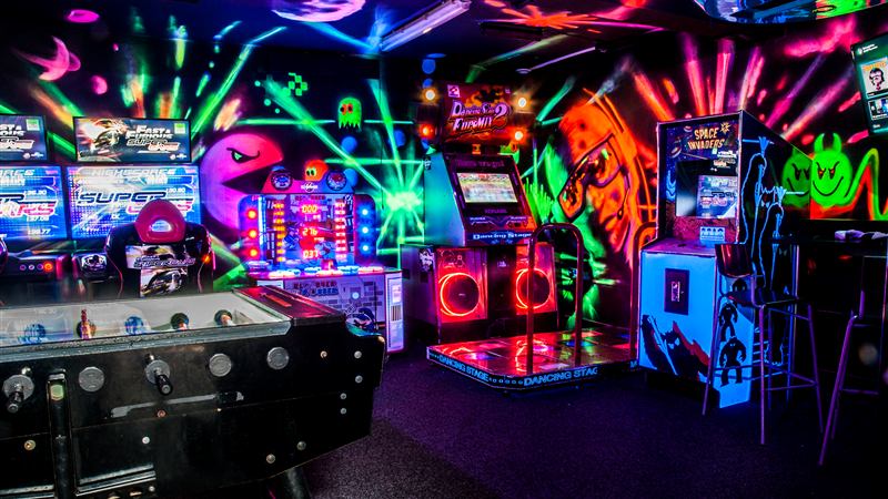The neon arcade room with games machines and a dance mat