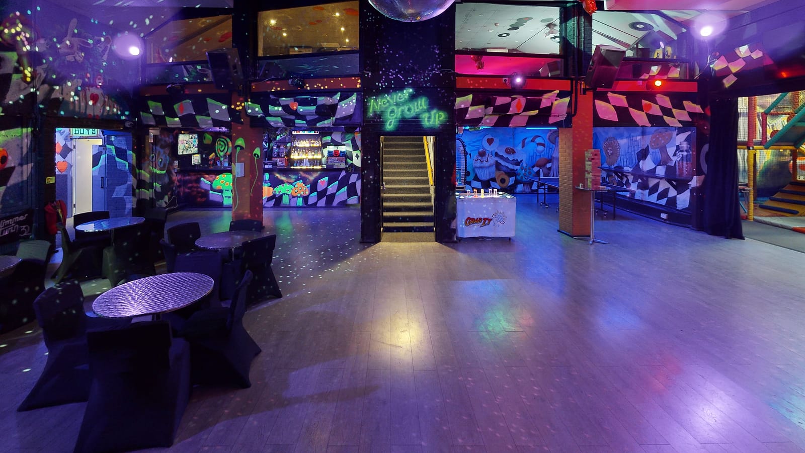 The main hall at night: tables and chairs under the mirror ball and disco lights